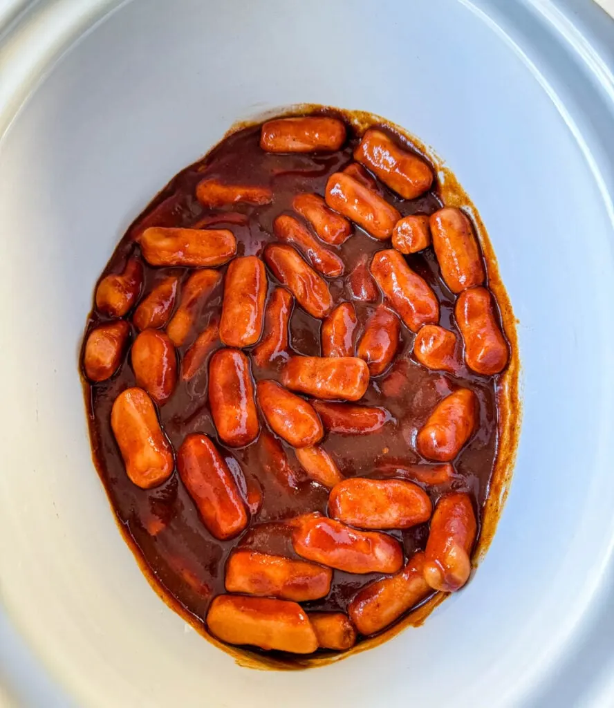 little smokies in a slow cooker Crockpot with BBQ sauce, brown sugar, chili powder, garlic powder, and smoked paprika