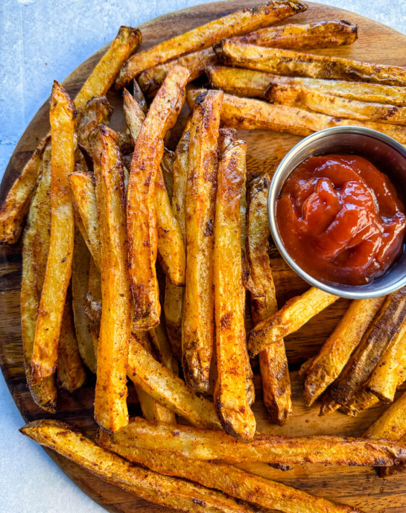 Cajun fries on a platter with ketchup