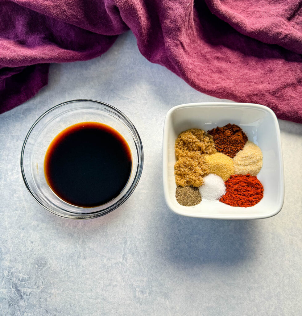 soy sauce in a glass bowl with homemade BBQ rub spices in a white bowl