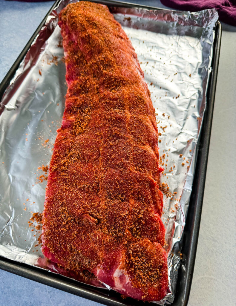 dry rub for ribs on a rack of ribs on a platter with foil