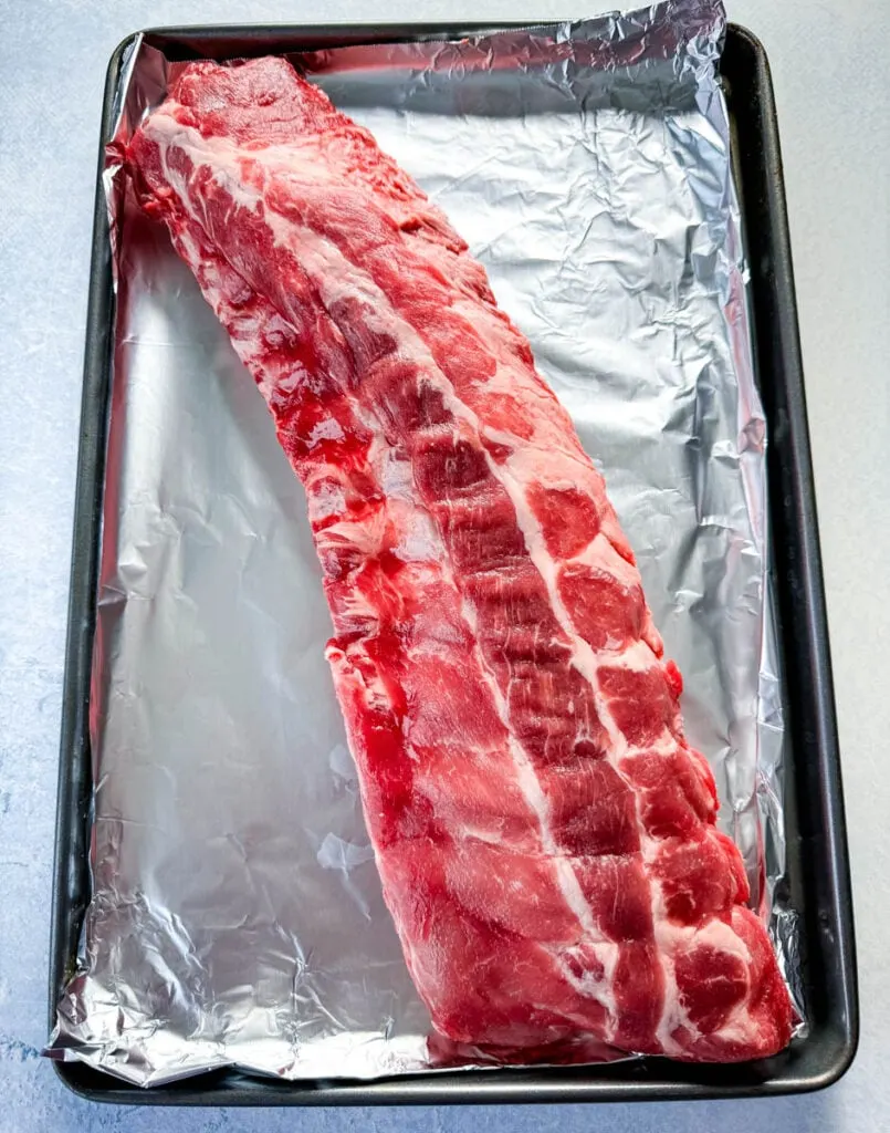 raw ribs on a sheet pan with foil