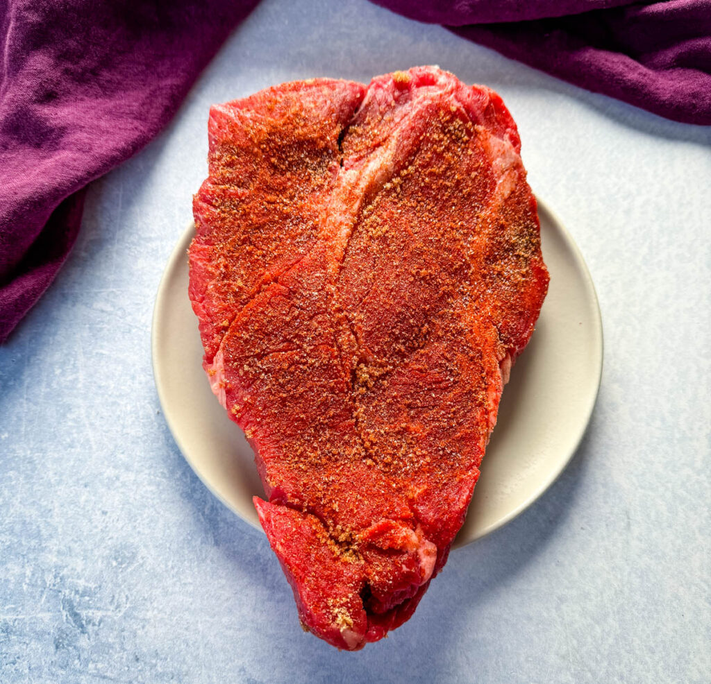 raw seasoned pot roast on a plate