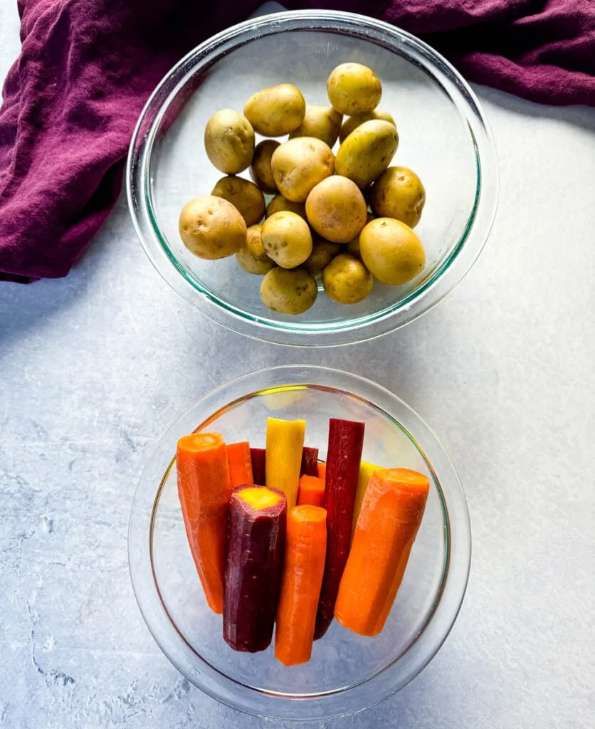 baby potatoes and carrots in separate glass bowls