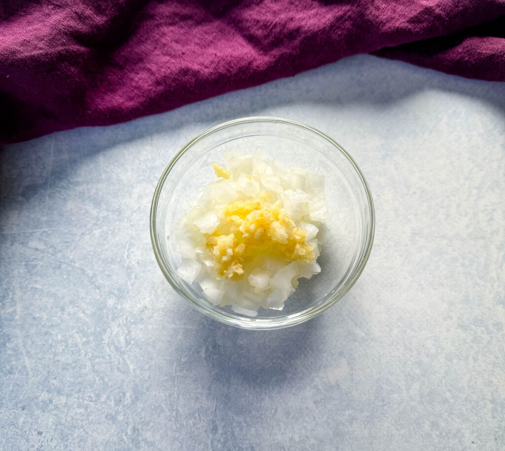 chopped onions and garlic in a glass bowl