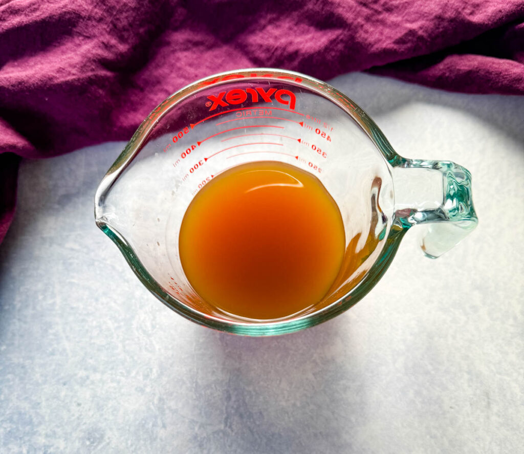 beef broth in a glass measuring group