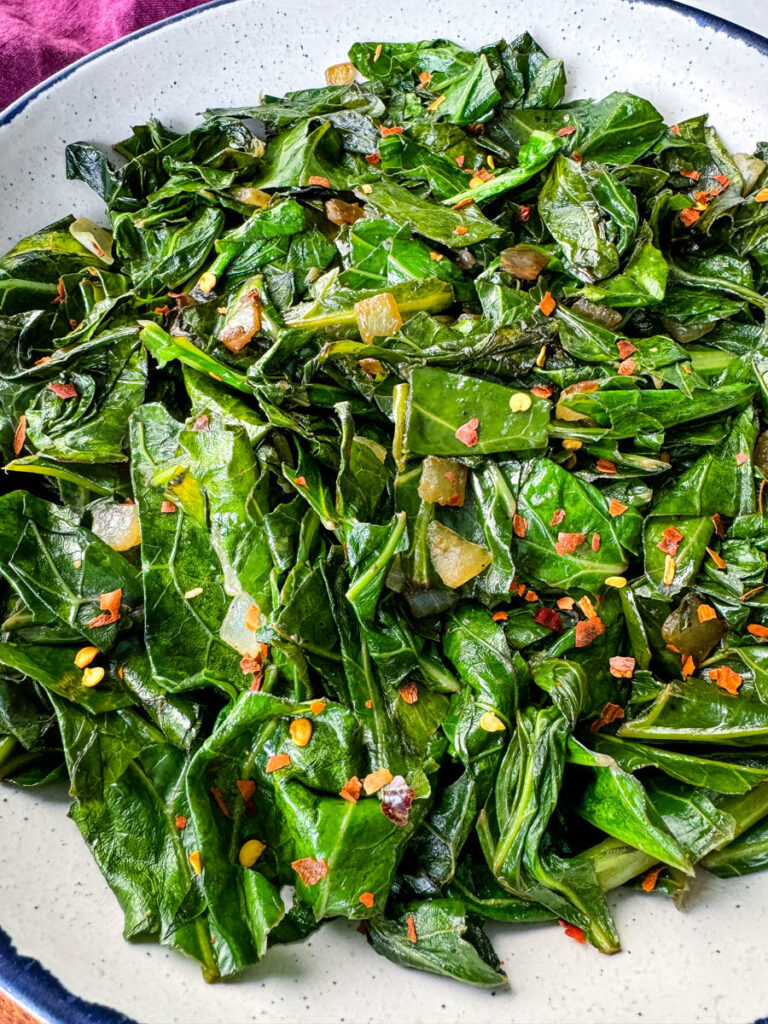 sauteed collard greens with crushed red pepper in a white bowl