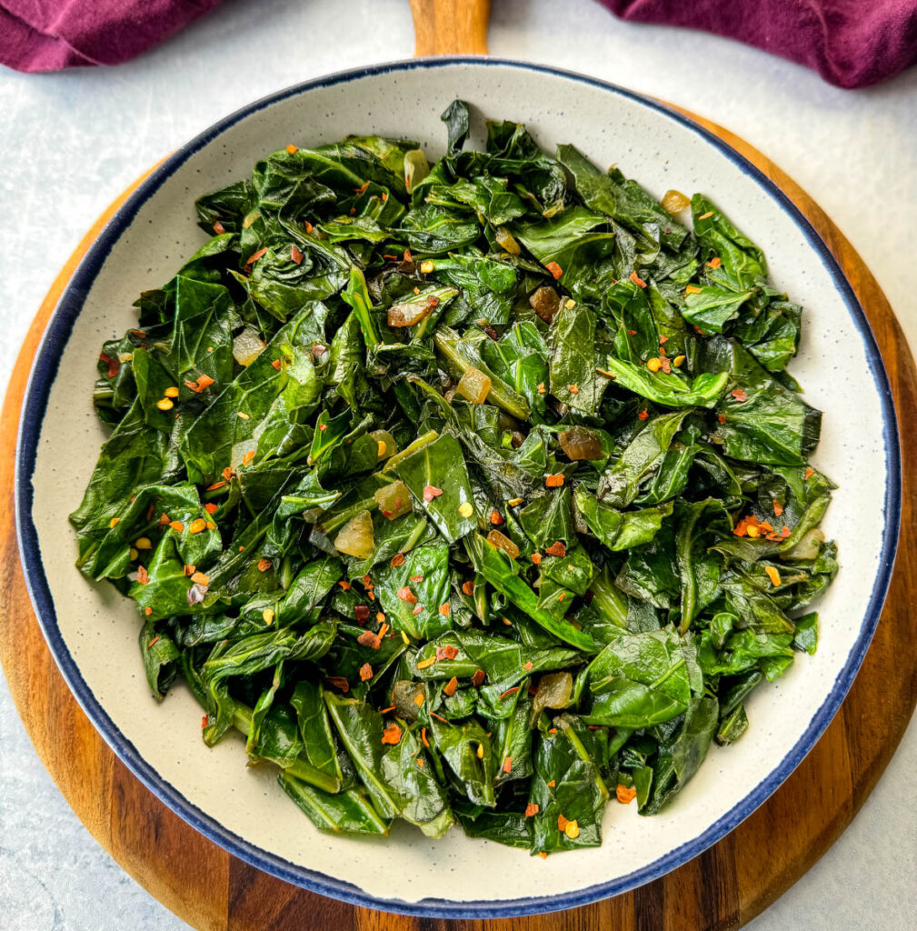 sauteed collard greens with crushed red pepper in a white bowl