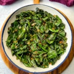 sauteed collard greens with crushed red pepper in a white bowl
