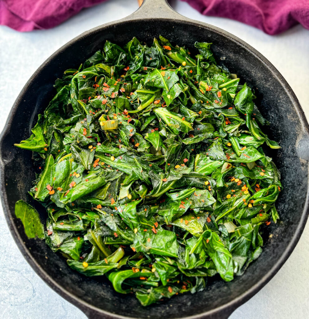 sauteed collard greens with crushed red pepper in a cast iron skillet