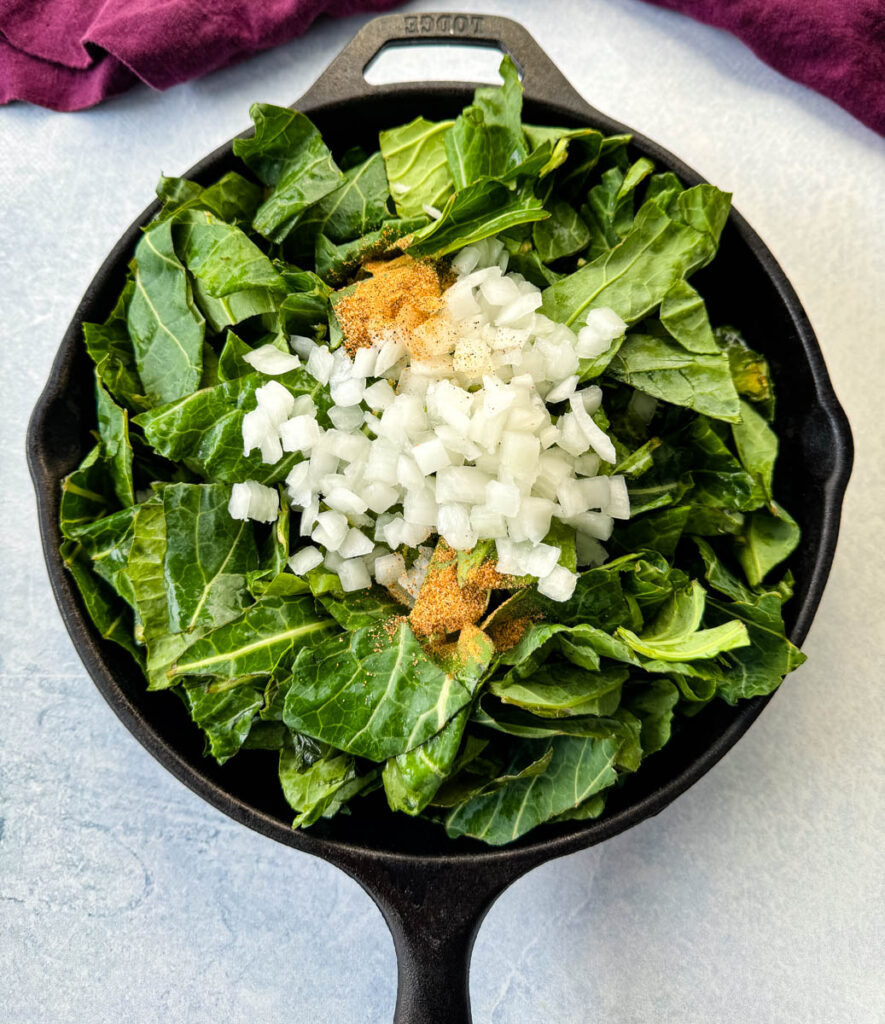 collard greens, white onions, garlic, and Creole Seasoning in a cast iron skillet