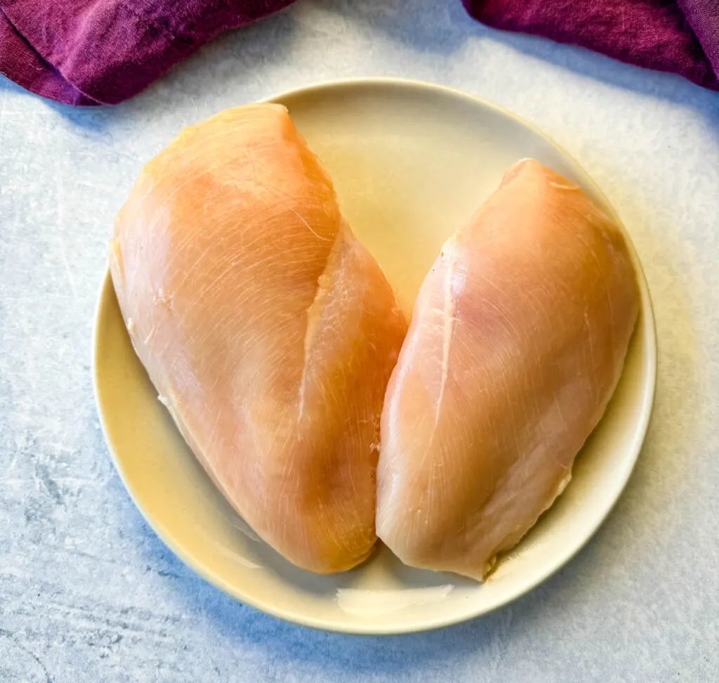 2 raw chicken breasts on a plate