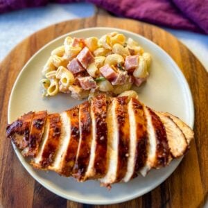 baked bbq chicken on a plate with pasta salad