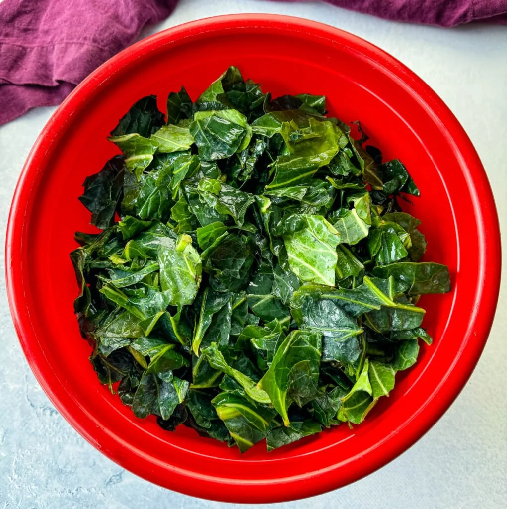 fresh, washed collard greens in a red bowl