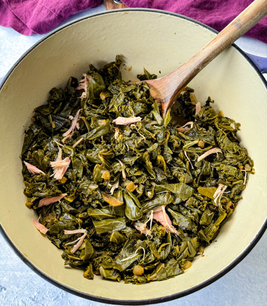 mixed greens, collard greens, turnip greens, mustard greens, and kale in a Dutch oven with a wooden spoon