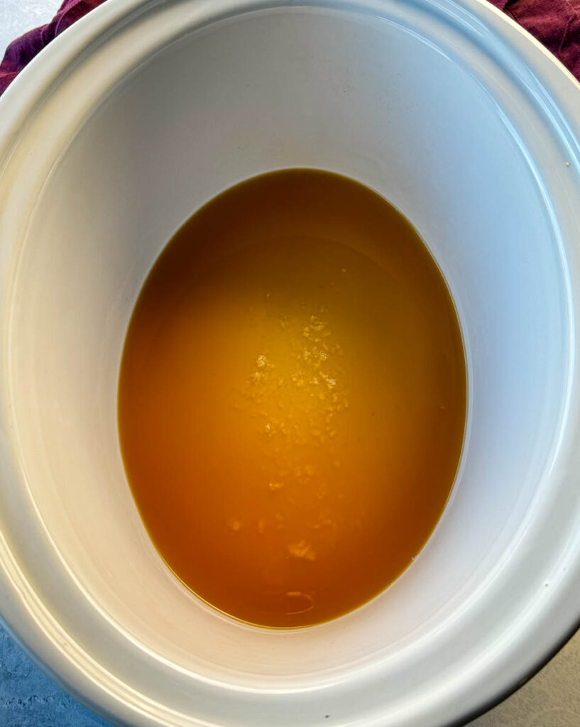 beef broth in a white slow cooker