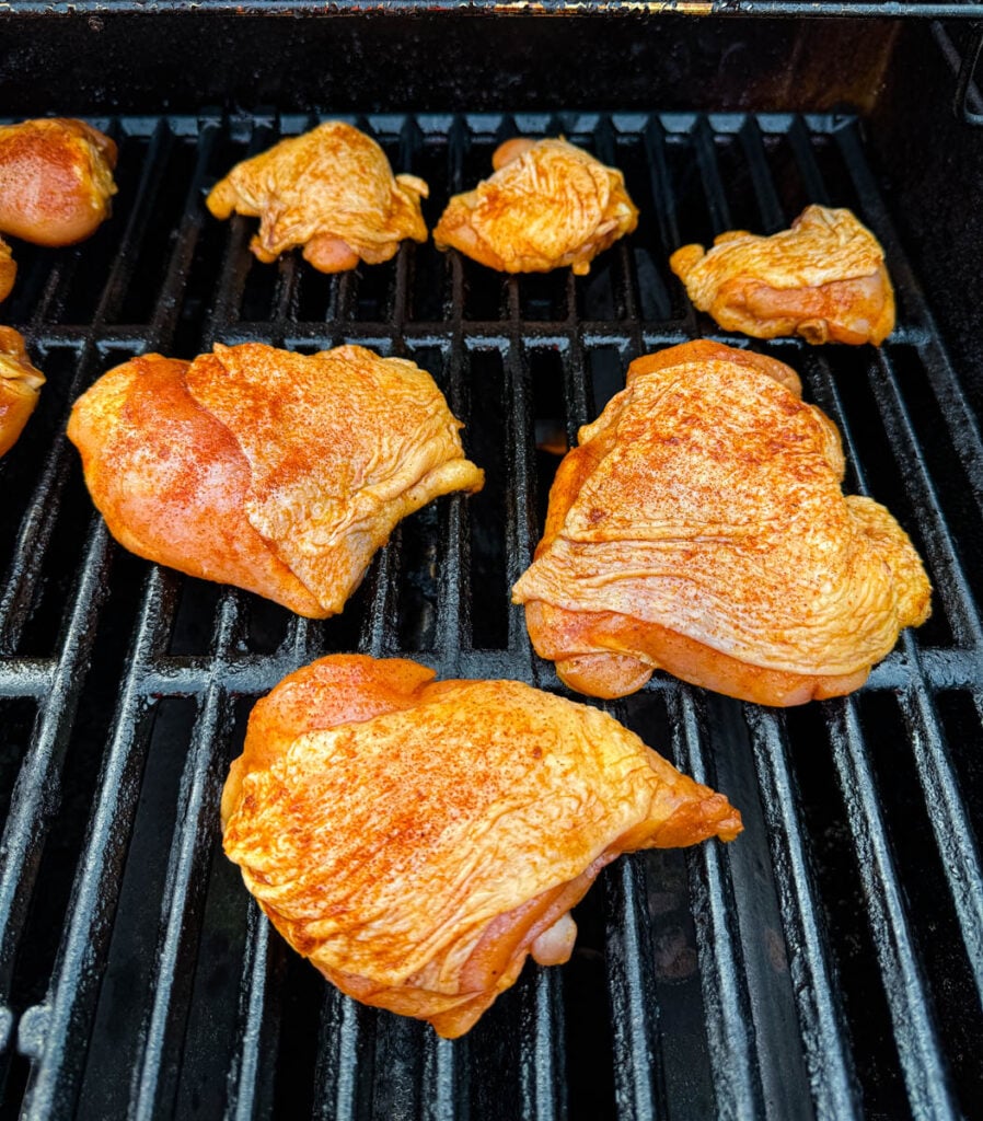 raw seasoned chicken thighs on grill