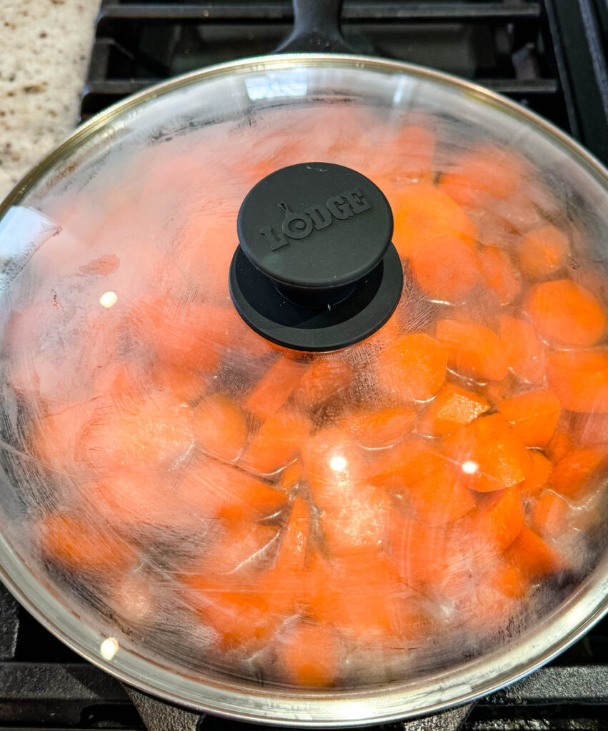 candied carrots with brown sugar cinnamon glaze in a cast iron skillet