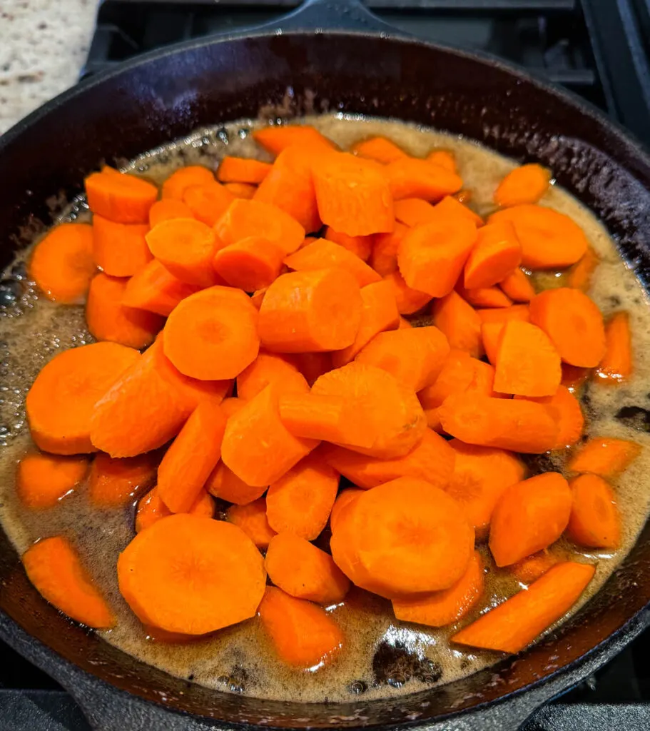 candied carrots with brown sugar cinnamon glaze in a cast iron skillet