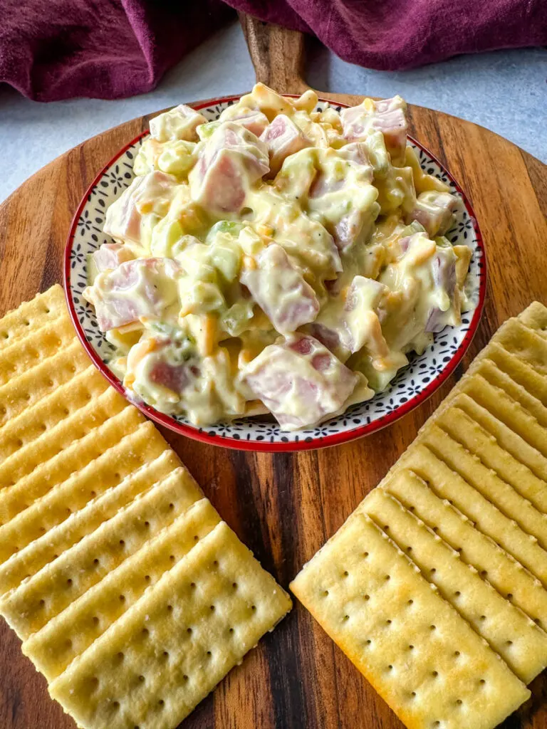 ham salad with cheese in a red bowl with crackers