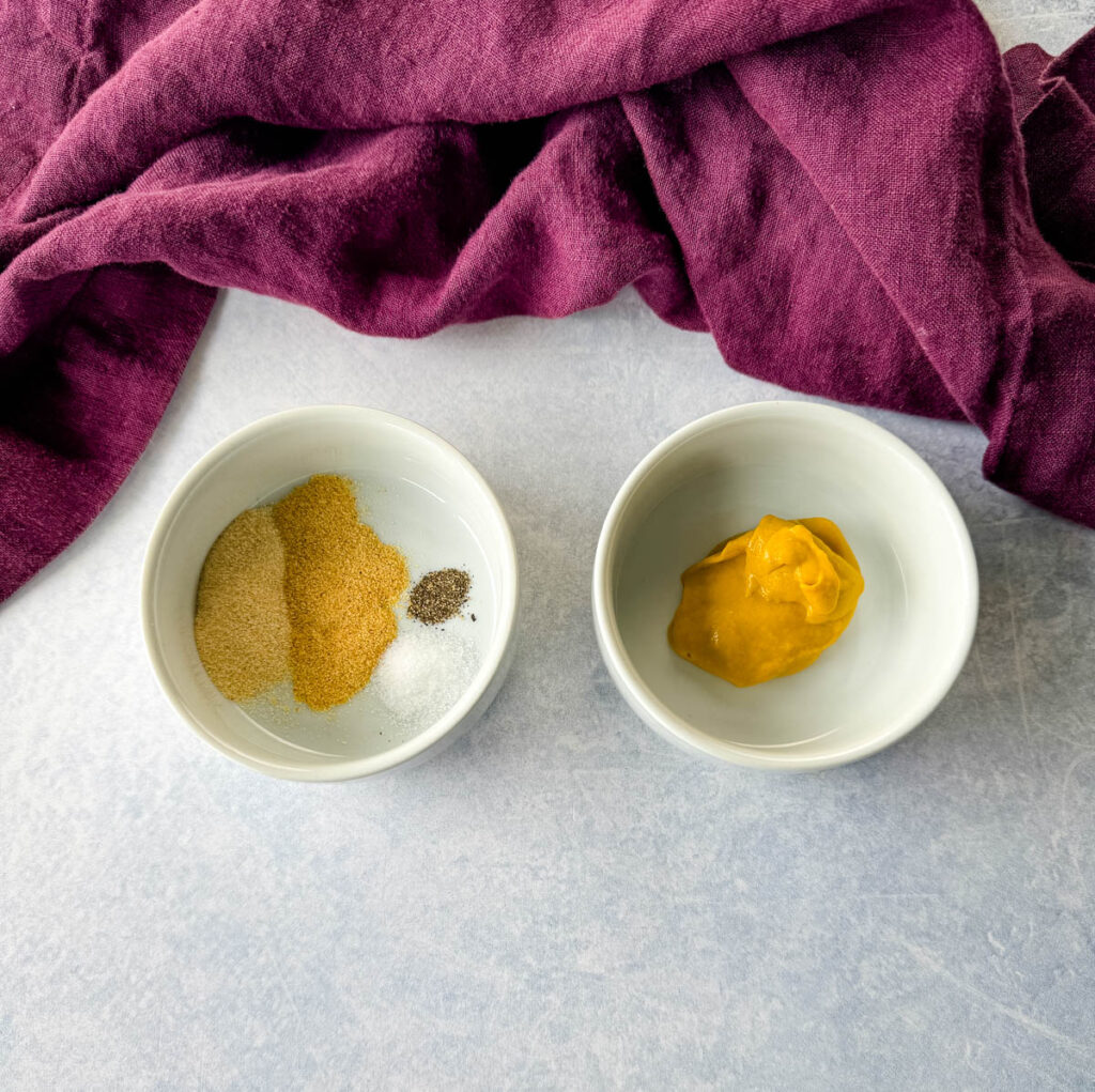 garlic powder, onion powder, salt, pepper, and mustard in white bowls