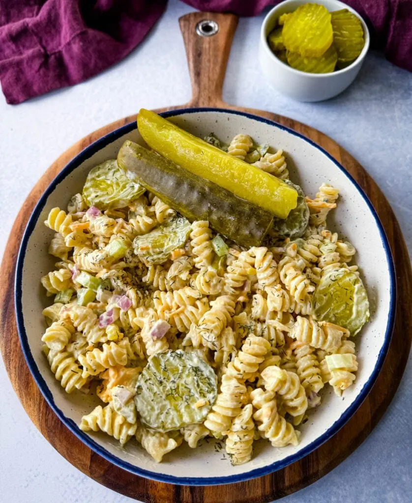 dill pickle pasta salad in a white bowl with pickle spears