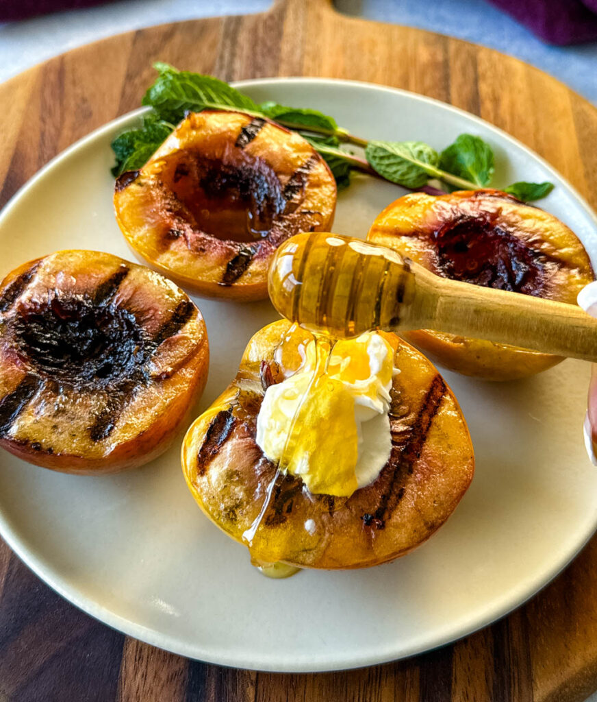 honey and whipped cream drizzled over a grilled peach