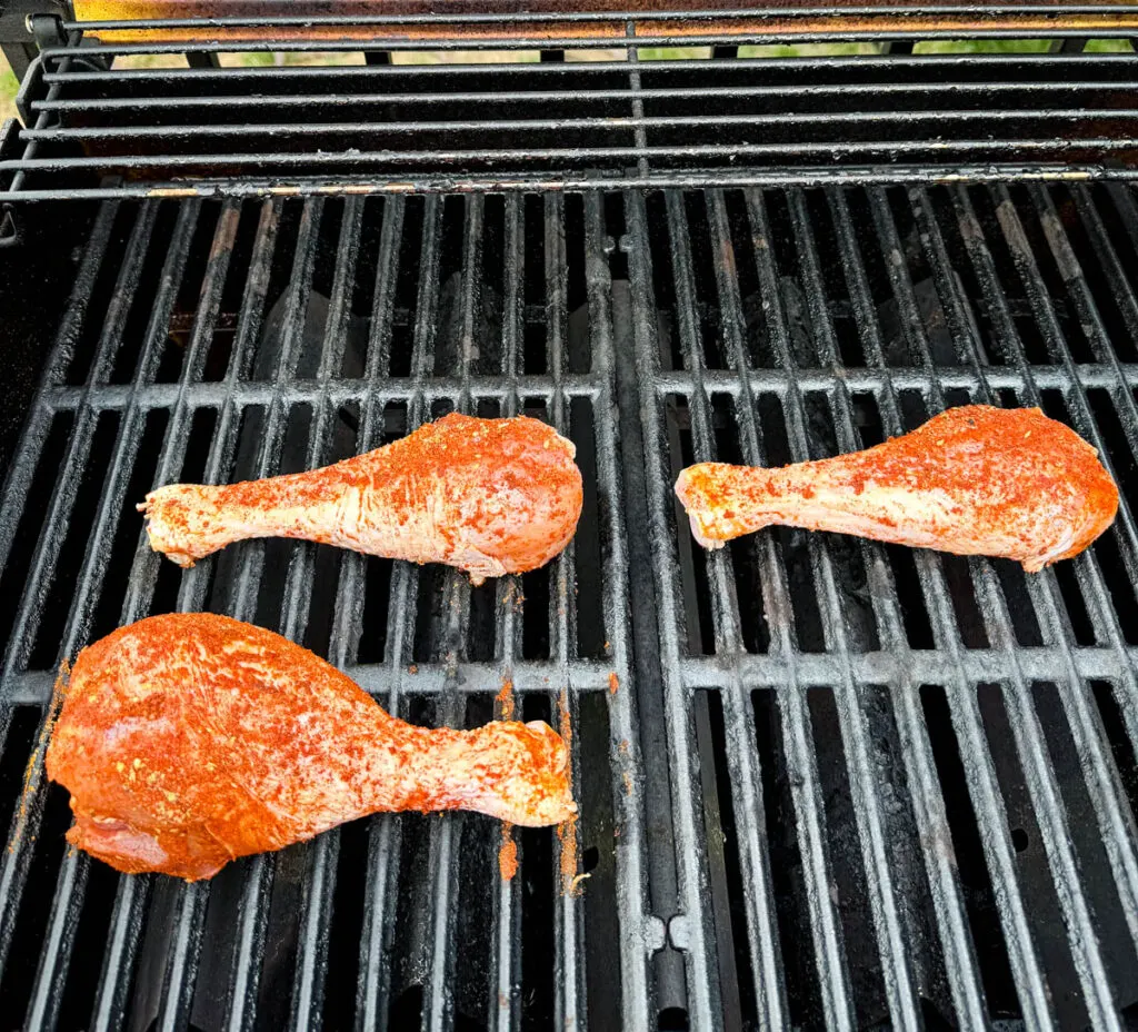 raw, seasoned turkey legs on a grill