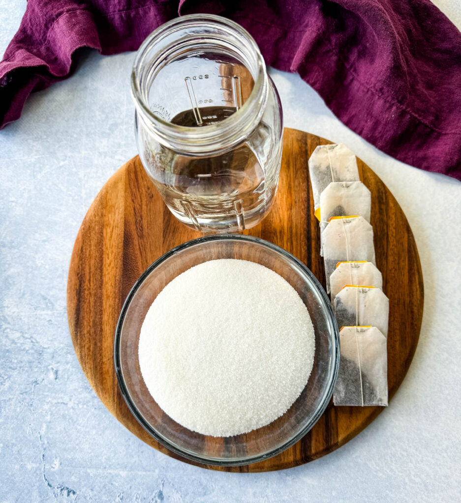 water, teabags, and sweetener or sugar on a flat surface