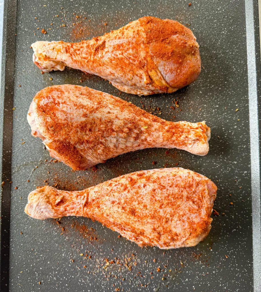 seasoned, raw turkey legs on a sheet pan