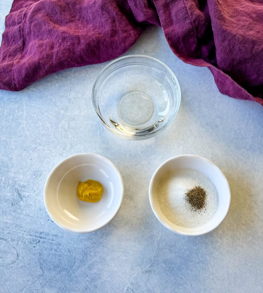 vinegar, mustard, sweetener, salt, and pepper in separate white bowls