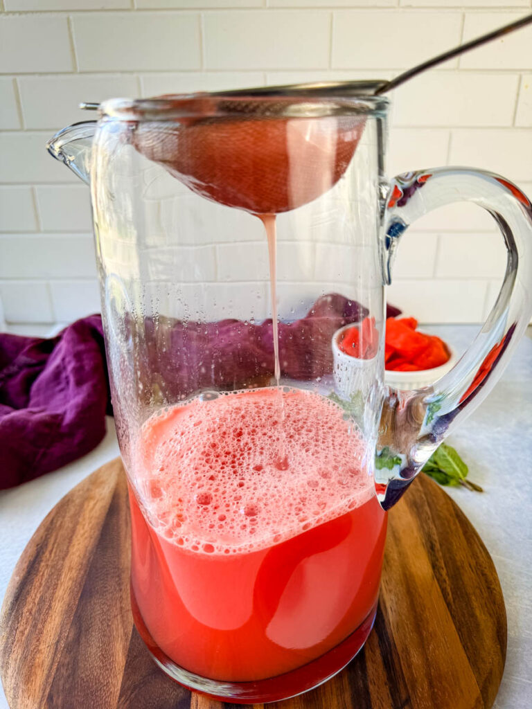 pureed watermelon strained into a pitcher