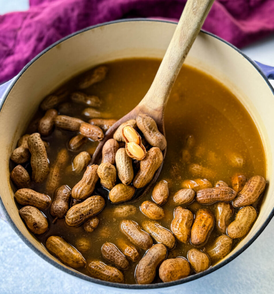 boiled peanuts in a Dutch oven with a wooden spoon