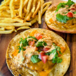 cheeseburger tacos with tomatoes, lettuce, and burger sauce on a plate with fries