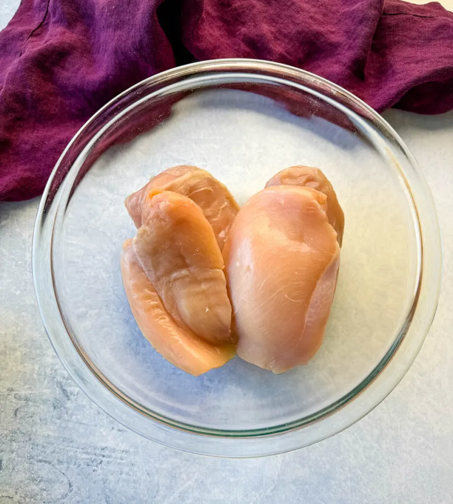 raw chicken breasts in a glass bowl