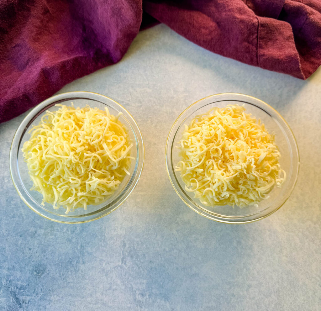 grated white cheddar cheese in separate glass bowls