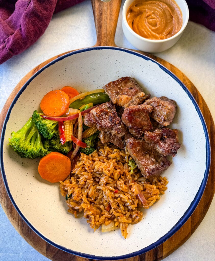 hibachi steak, vegetables, and fried rice in a white bowl