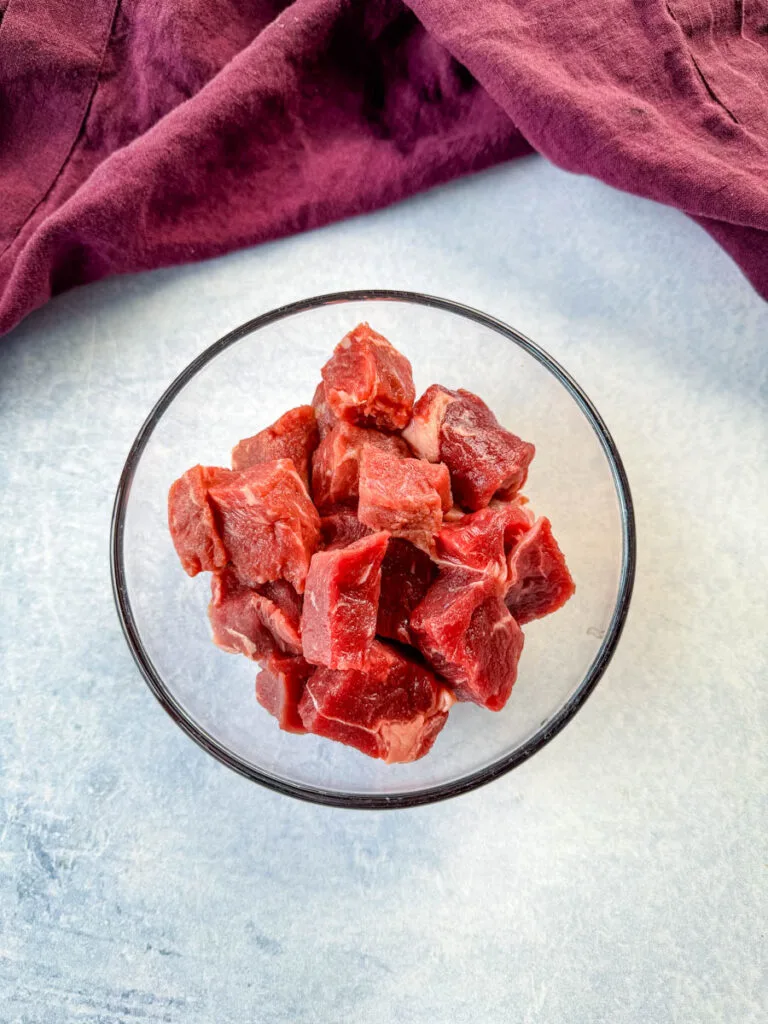 raw steak diced into pieces in a glass bowl