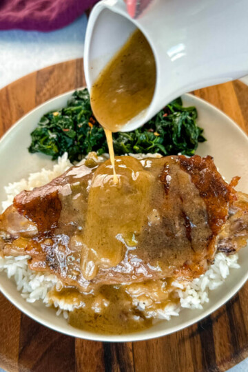 turkey wing on a plate with spinach drizzled with gravy