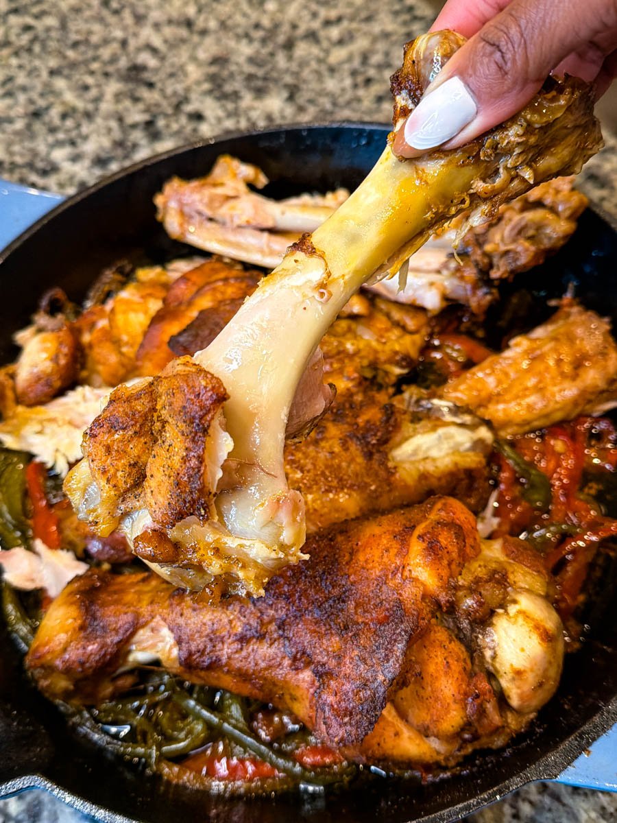 person holding baked turkey wing with meat falling off the bone