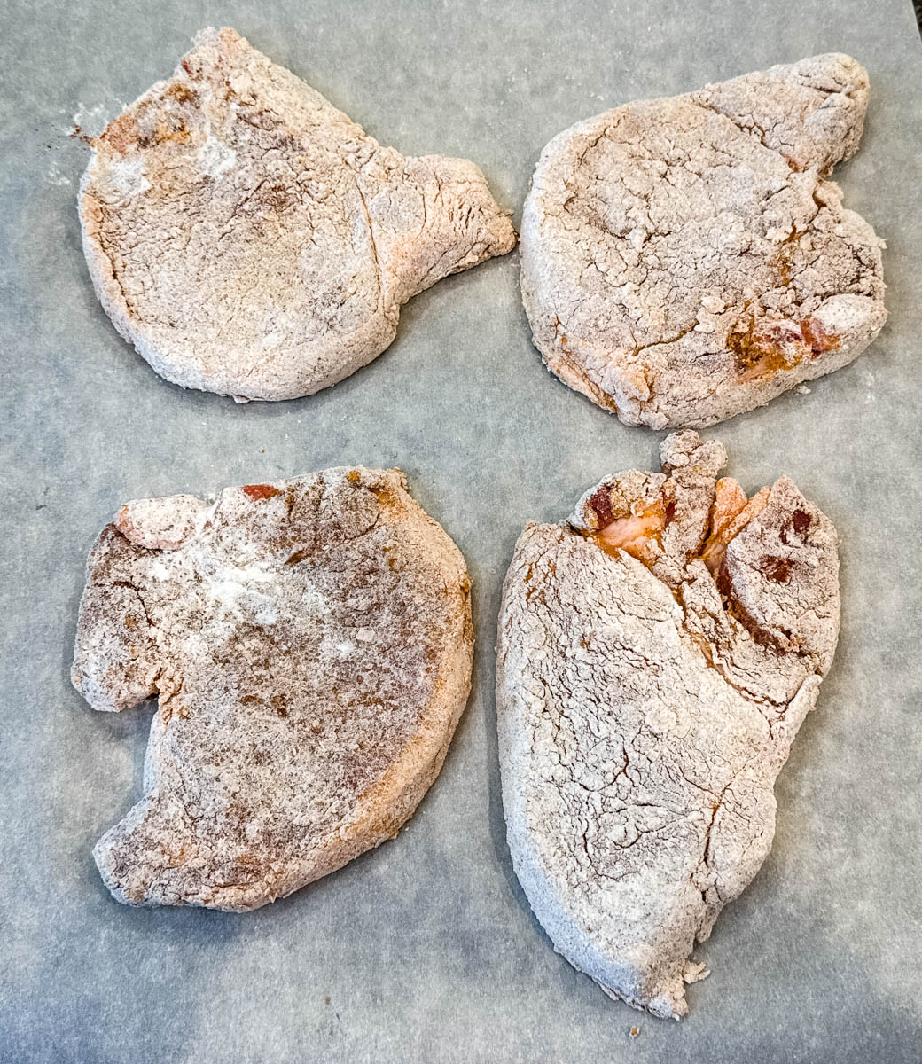 raw seasoned pork chops coated in flour