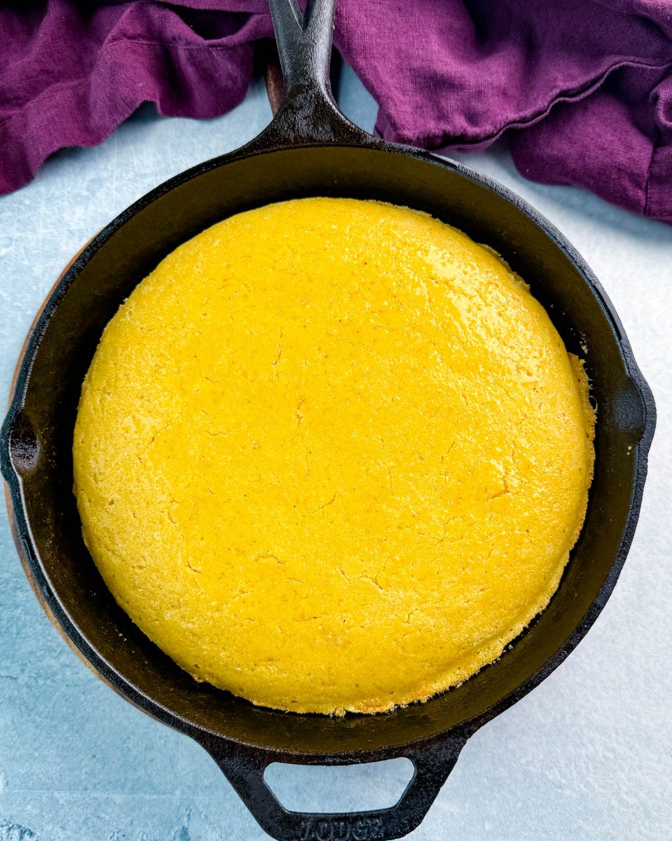 Southern cornbread baked in a cast iron skillet—crispy edges and golden top, fresh from the oven.