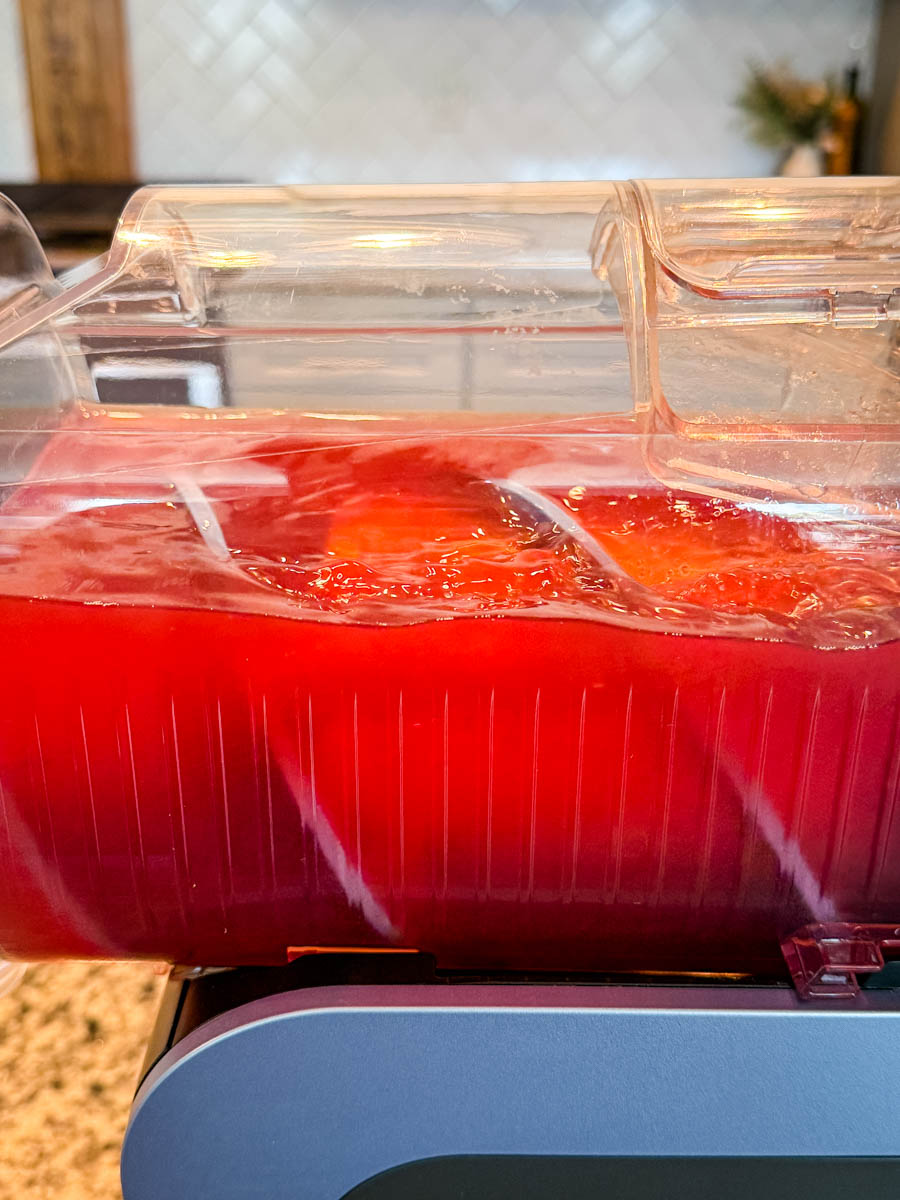 The Ninja Slushi machine filled with fruit punch and ice, ready to be processed.
