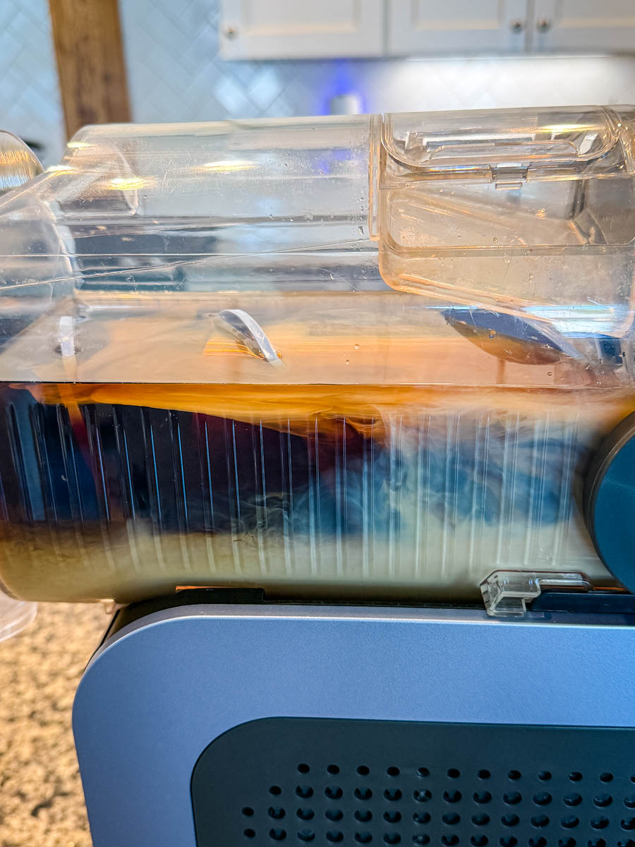 Side view of the Ninja Slushi machine in action, showing espresso martini mixture churning inside.