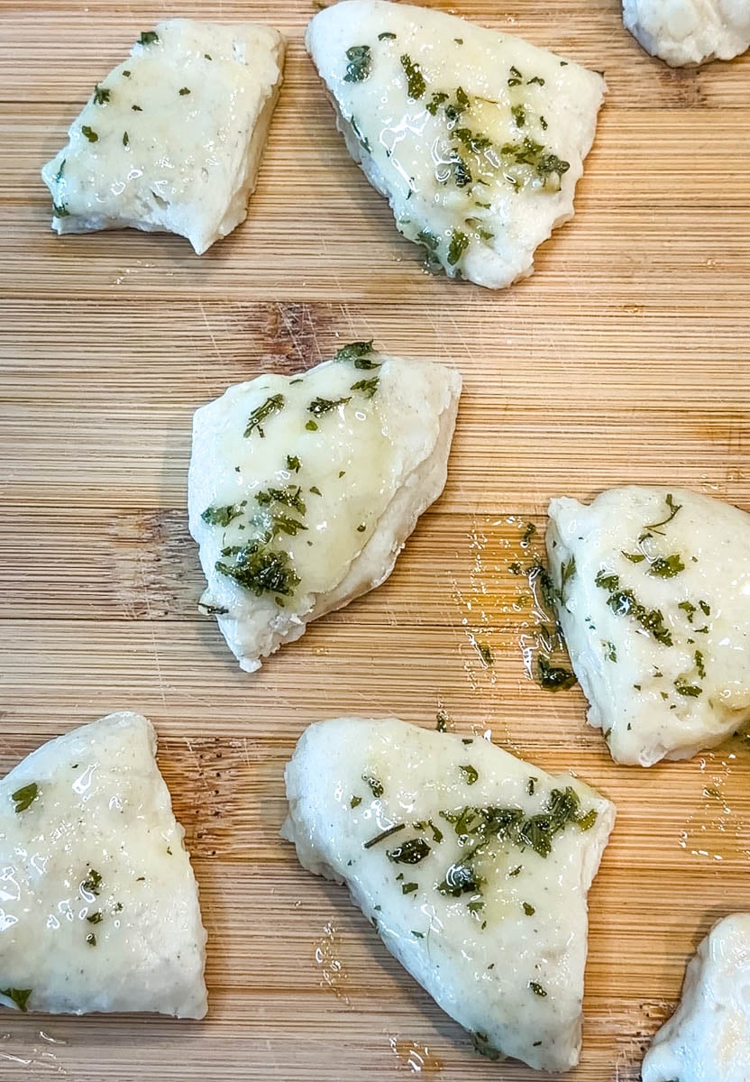 biscuit dumplings with butter and garlic on a cutting board