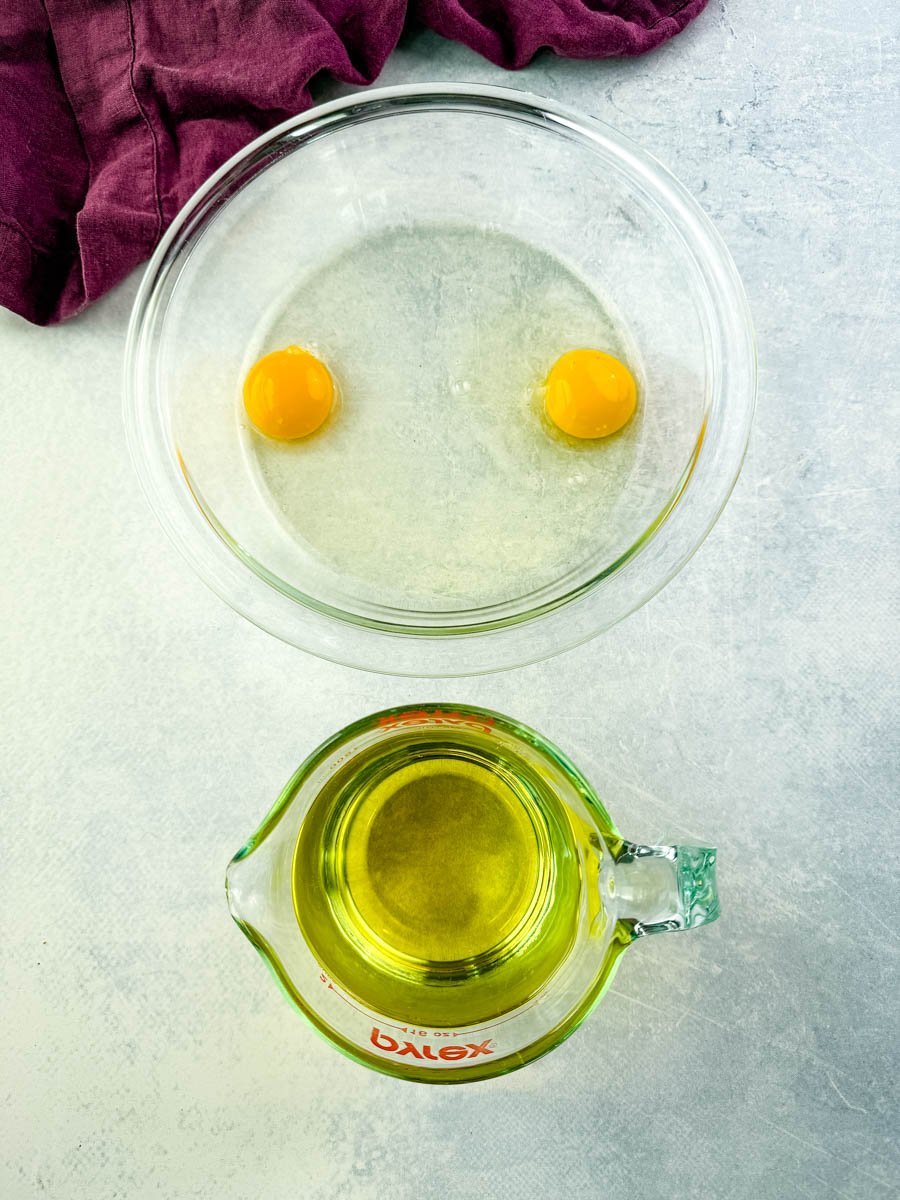 raw eggs and canola oil in separate glass bowls