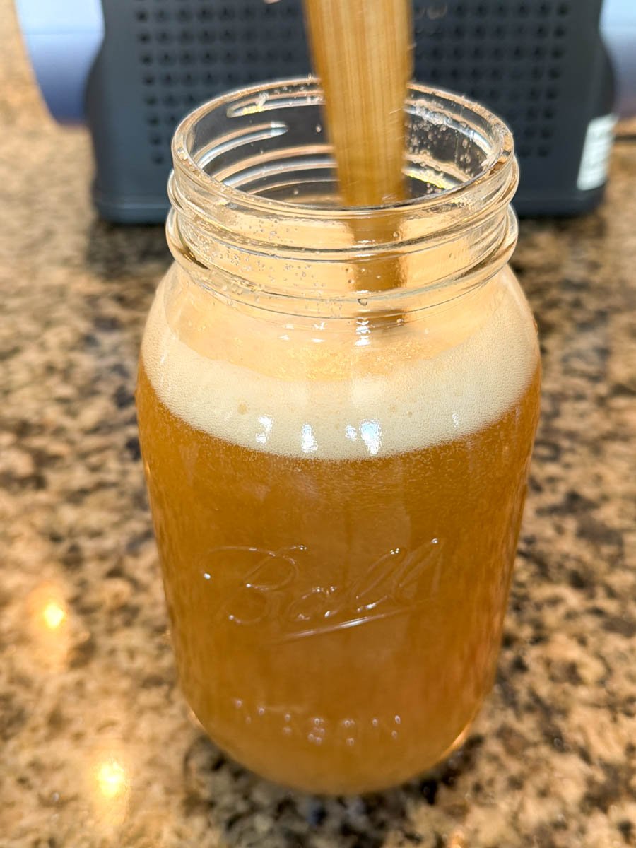A mason jar filled with freshly blended Butter Beer mixture, foamy at the top.