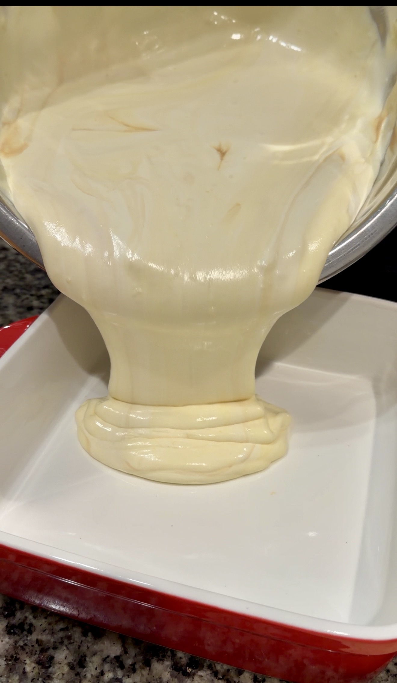 Thick, smooth banana pudding mixture poured into an empty baking dish, showing a creamy, glossy texture.