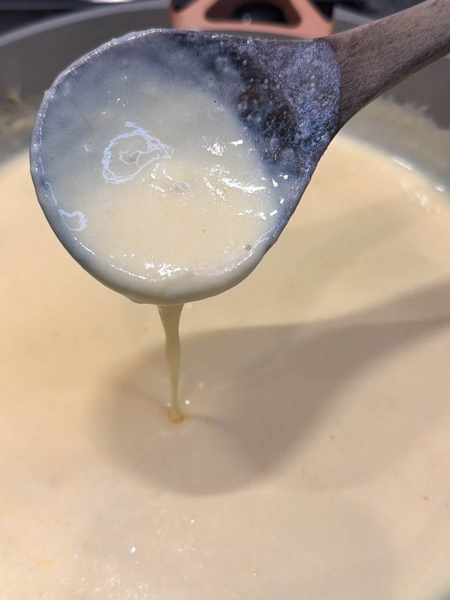 cream sauce in a pot with a wooden spoon
