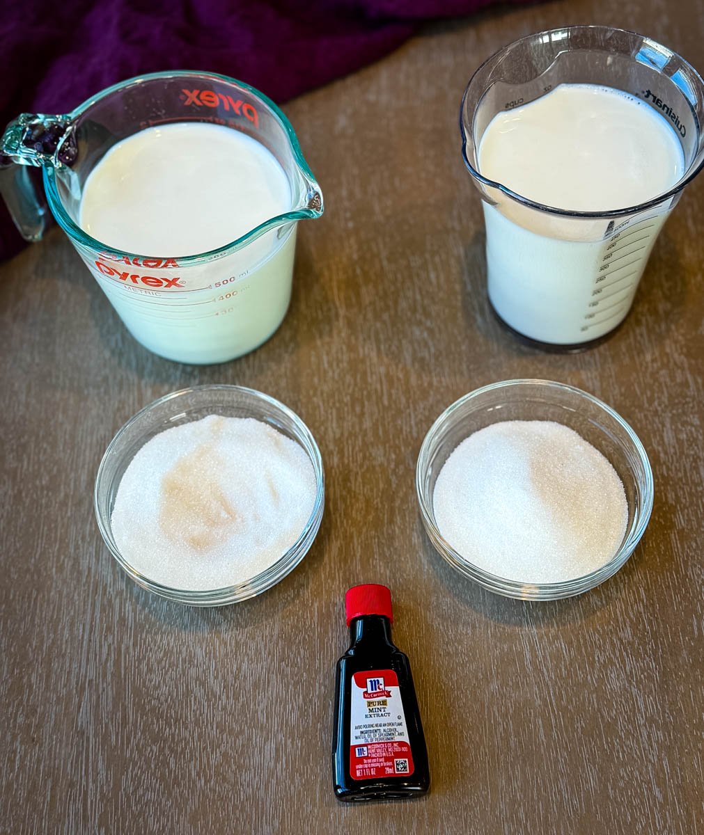 Measured milk, cream, sugar, and mint extract arranged for shamrock shake ingredients.