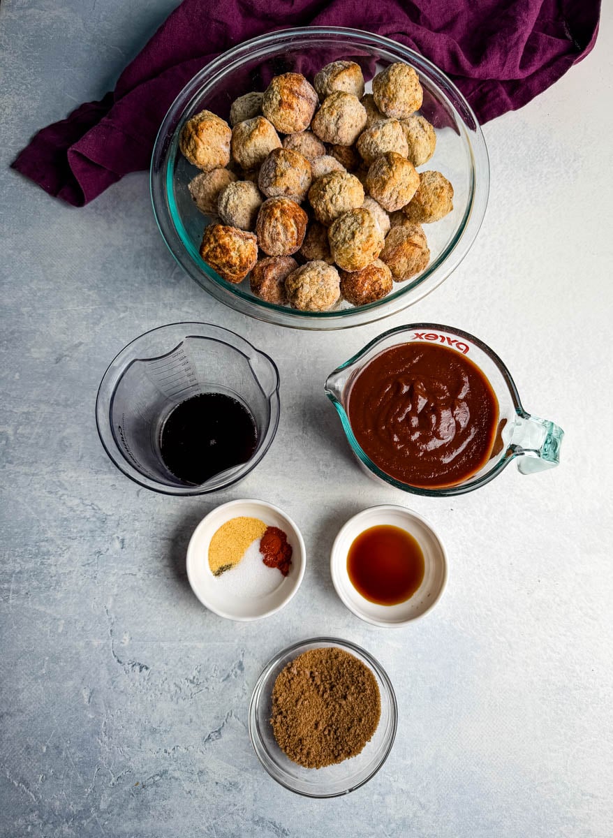Frozen meatballs with BBQ sauce, brown sugar, and spices measured out for easy appetizer prep